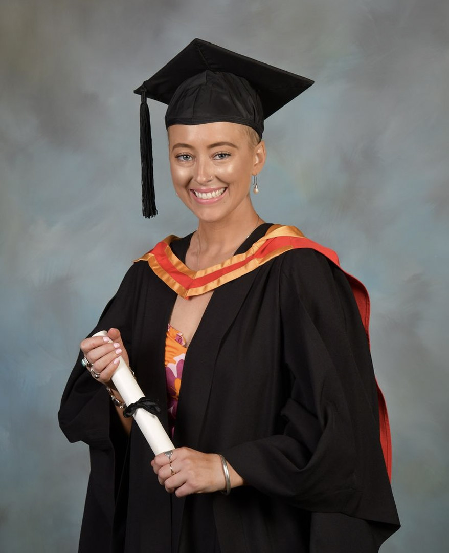 Formal portrait of Courtney Hughes holding her Bachelors Degree from Charles Sturt University.